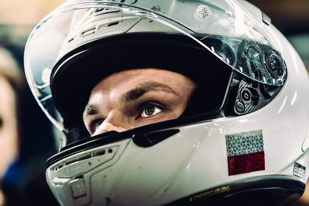 Intimate helmeted rider portrait showing preparation and concentration