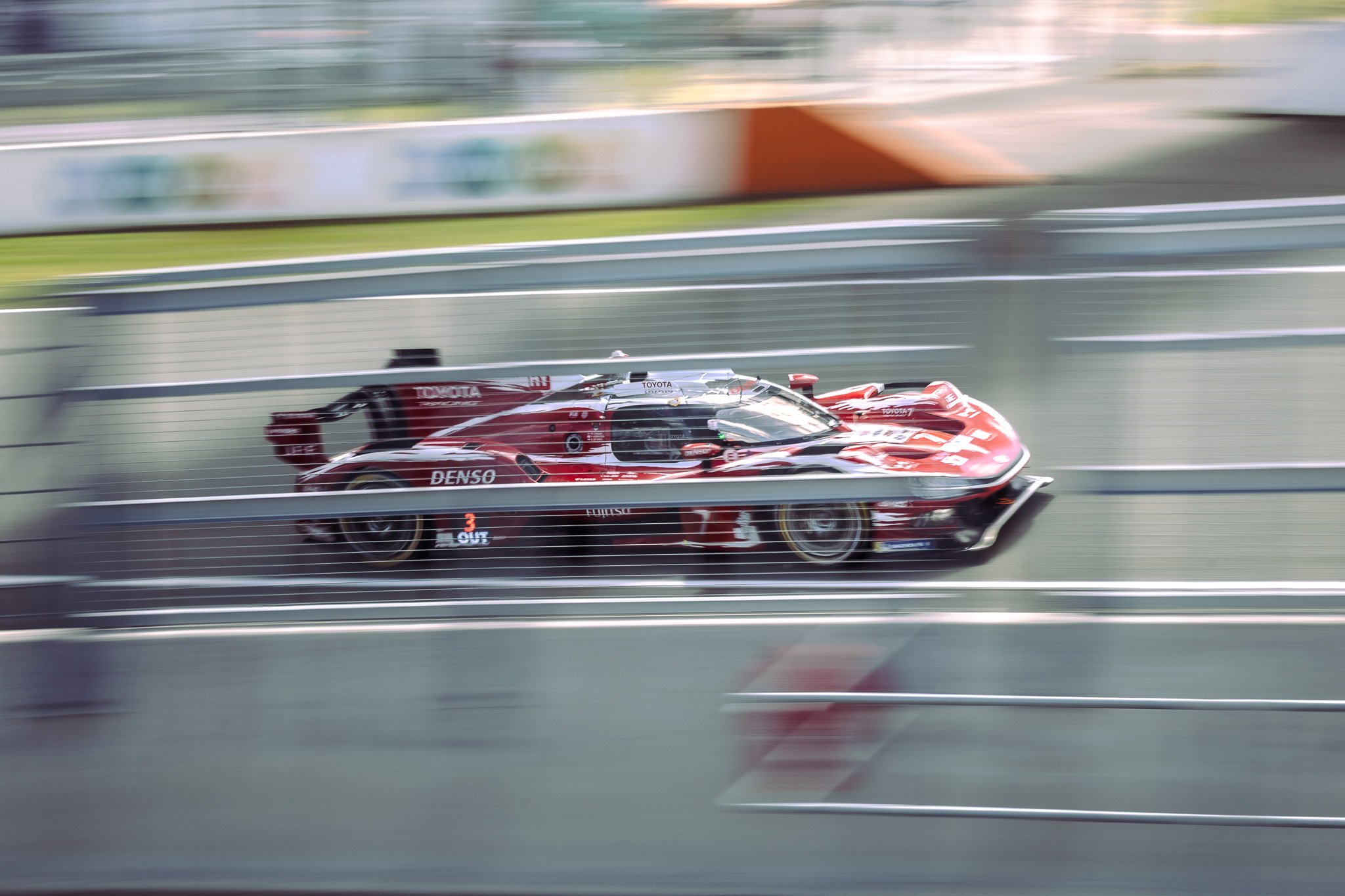 Photographe endurance - filé artistique d'une Hypercar Toyota à travers les grillages