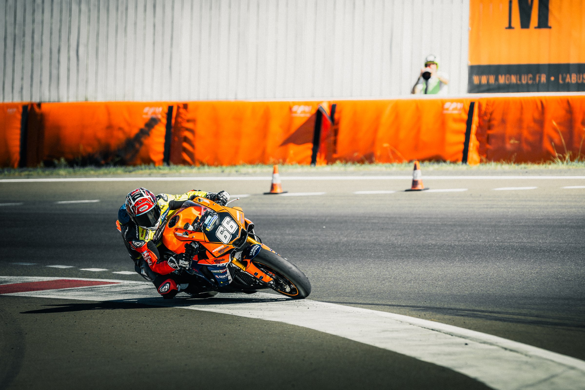 Photographe course moto - pilote en angle serré dans un virage, image artistique