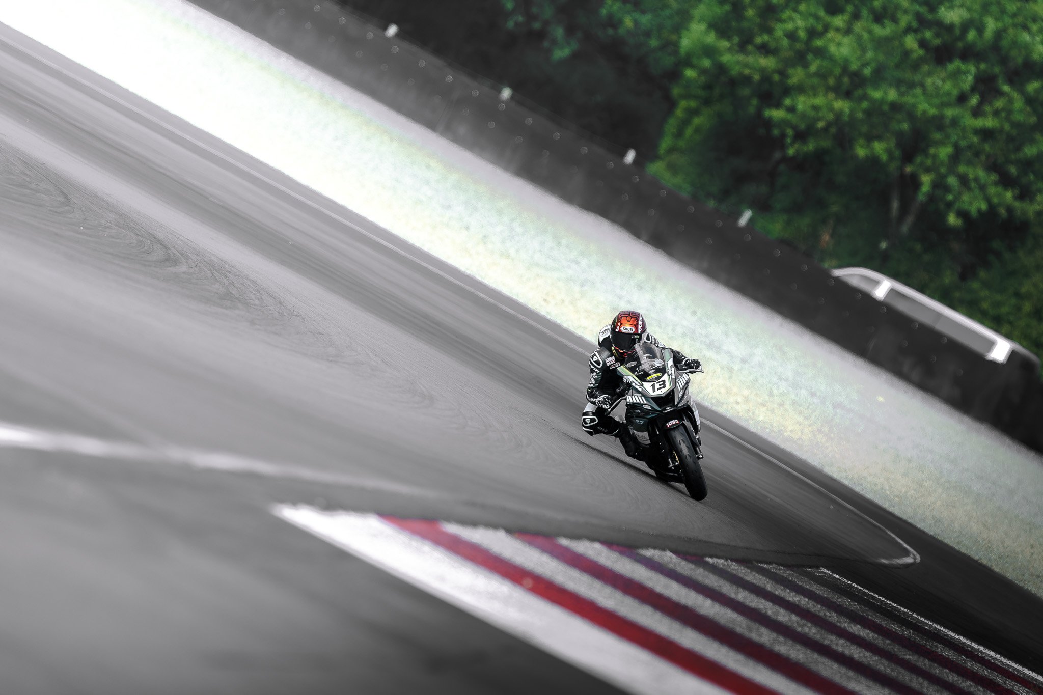 Photographe course moto - virage sous la pluie, ambiance cinématique